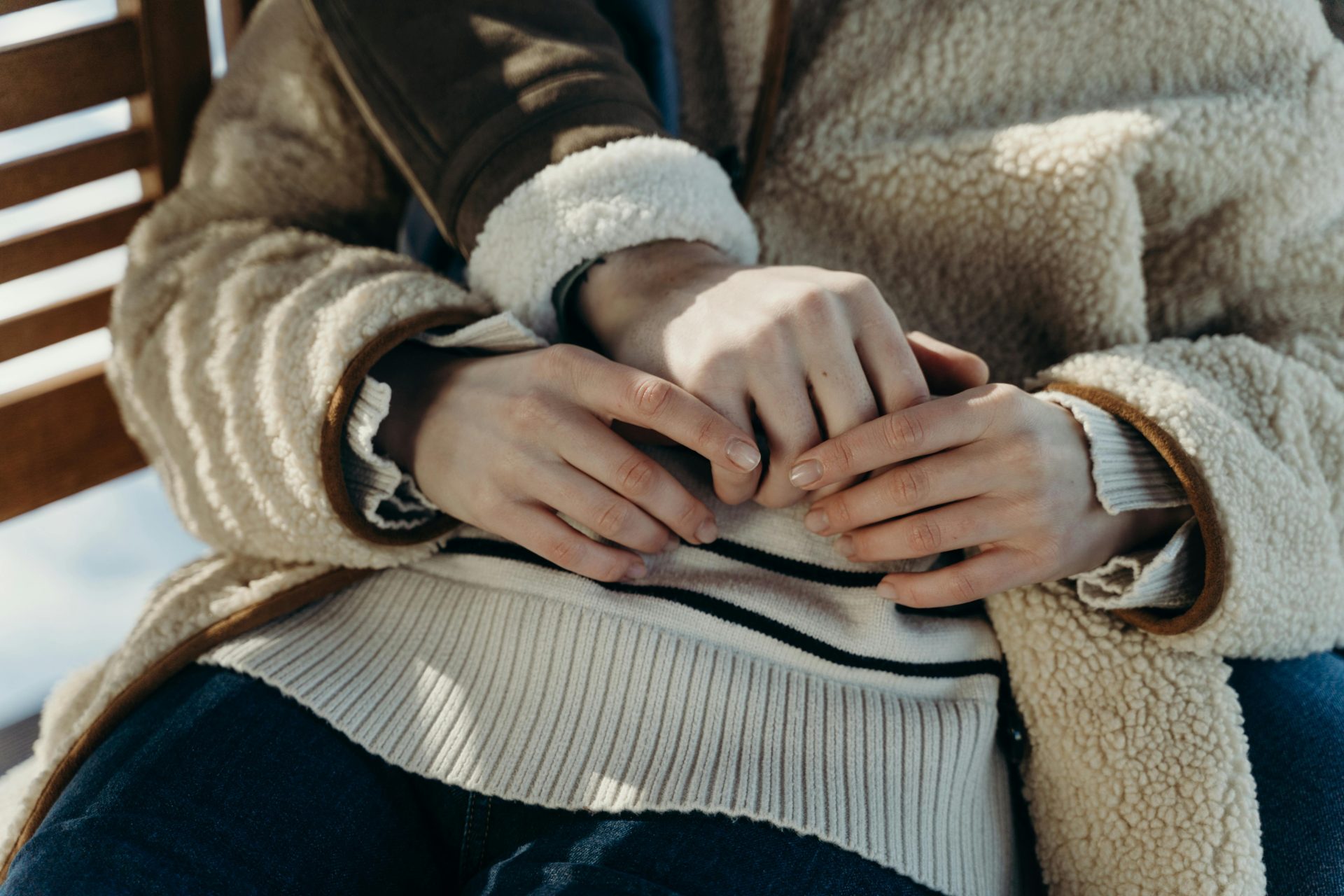 A close-up of a couple holding hands, dressed in warm winter clothing, representing affection and intimacy.